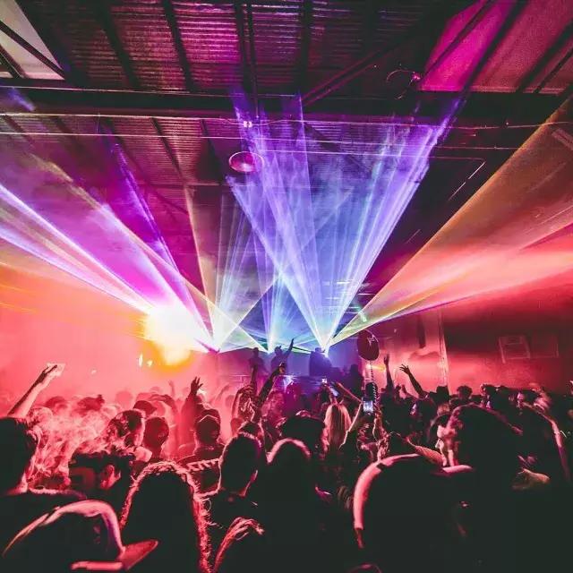 Immagine di persone che si frequentano in un night club dalle luci colorate